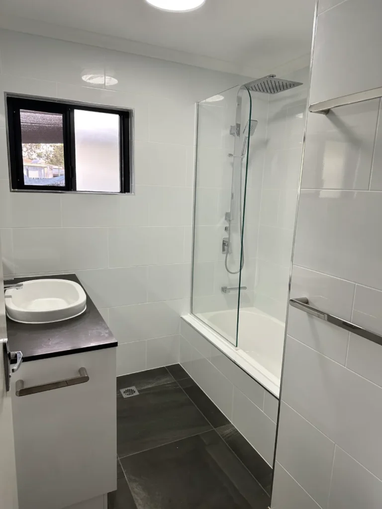 Shower over tub and chrome fixtures to ensure a small bathroom is practical
